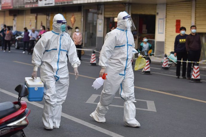 10 April 2022, China, Fuyang: Medical personnel in protective suits walk on a street, in a cordoned-off area in Fuyang. Mainland China reported 1,318 new confirmed local corona cases on Saturday 09 April, up from 1,334 on Friday, the National Health Com
