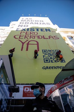 Archivo - Tres escaladores de Greenpeace se descuelgan sobre una lona para hacer un grafitti, en Gran Vía, a 20 de enero de 2022 