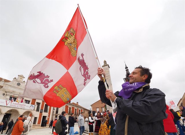 Un hombre ondea una bandera de Castilla y León en la Plaza Mayor de Villalar de los Comuneros.