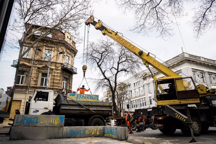 18 April 2022, Ukraine, Odesa: Workers use a crane to remove concrete barriers along city streets in Odesa. Photo: Vincenzo Circosta/ZUMA Press Wire/dpa