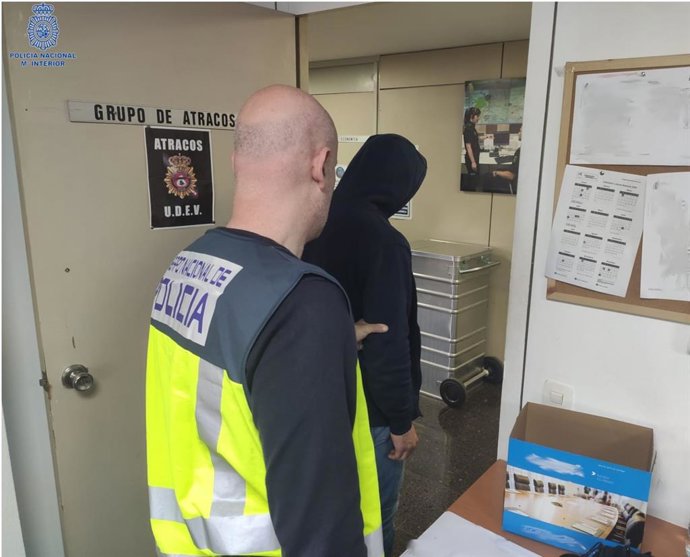 Uno de los arrestados, conducido por uno de los agentes.