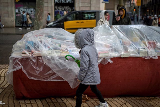 Una parada de llibres coberta amb plàstic, a la Diada de Sant Jordi del 2022