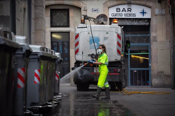 Archivo - Una trabajadora limpia una vía de Barcelona, a 26 de julio de 2021, en Barcelona. ARCHIVO
