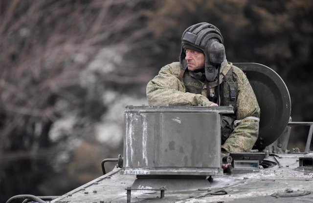 Archivo - Un militar ruso monta un vehículo blindado de transporte de personal.  