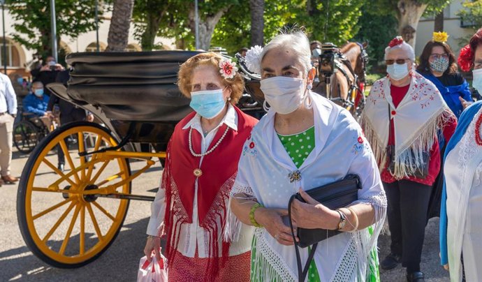 Archivo - Varias mujeres ataviadas de flamenca tras bajarse de un coche de caballos, en foto de archivo.