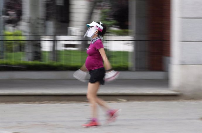 Archivo - Una mujer embarazada y con visera de protección pasea cartel durante el tercer día de la desescalada del Gobierno en la fase 0. 