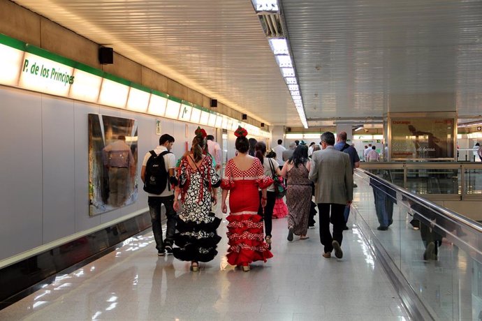 Archivo - Mujeres vestidas de flamenca en una estación de Metro.
