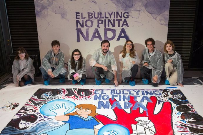 El ilustrador Isaac Sánchez, @Loulogio, junto a los ganadores del concurso tras pintar el mural 'El bullying no pinta nada'.