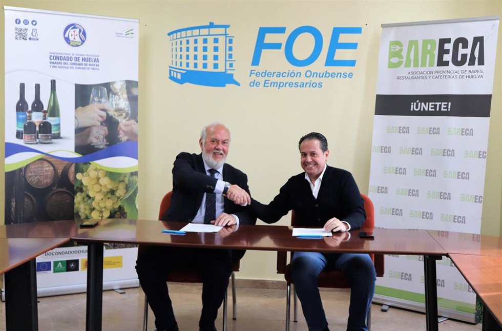 El presidente del Consejo Regulador de las denominaciones de origen protegidas Condado de Huelva, Manuel Infante, y su homólogo de la Asociación Provincial de Bares, Restaurantes y Cafeteterías, Rafael Acevedo, firman un convenio de colaboración.