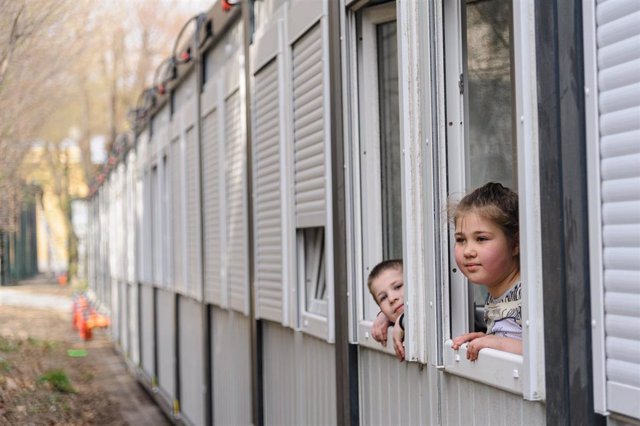 Dos niños ucranianos miran por la ventana de un centro para desplazados.