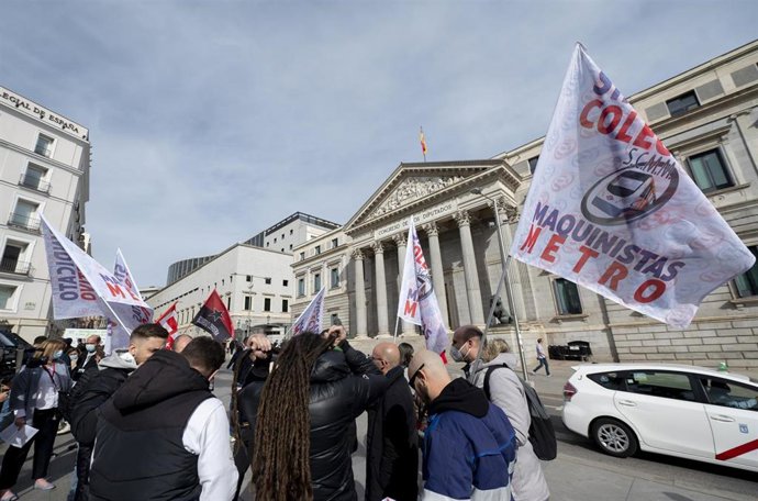 Archivo - Varias personas con banderas de los sindicatos del comité de empresa de Metro de Madrid, participan en una concentración frente al Congreso de los Diputados, a 23 de febrero de 2022. Archivo.