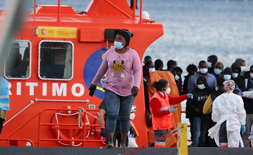 Archivo - Una migrante llega a tierra junto con otras personas tras ser rescatados por la salvamar Mizar