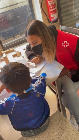Voluntaria de Cruz Roja Huelva atediendo a un niño ucraniano.