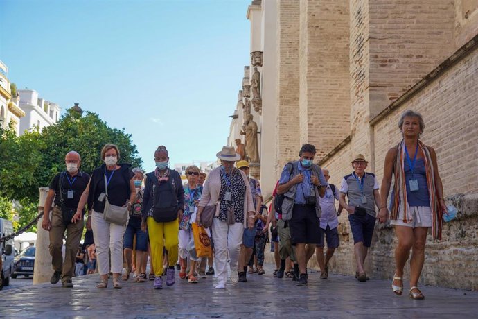 Archivo - Gran cantidad de turistas por el entorno de  la Catedral de Sevilla, en foto de archivo.