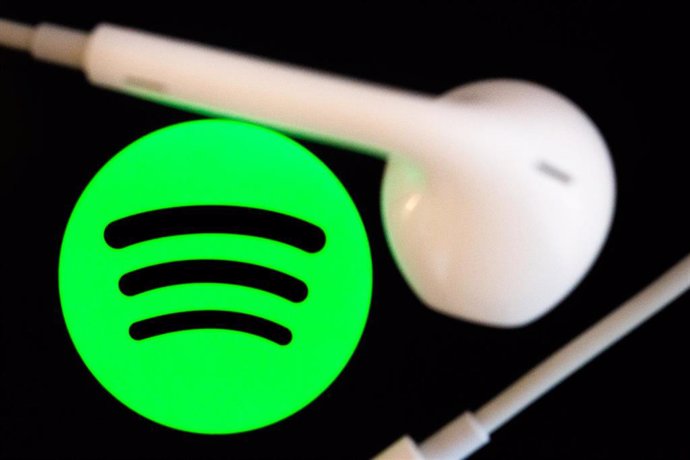 Archivo - FILED - 07 February 2022, Berlin: Headphones are on the screen of a smartphone, which displays the logo from the music streaming service Spotify. Spotify is closing its offices in Russia because of Moscow's invasion of neighbouring Ukraine. Ph