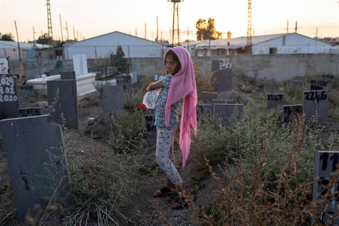 Archivo - 03 August 2021, Turkey, Caldiran: A young girl tries to sell water to visitors at the cemetery of the eastern Anatolian town, where lie the corpses of dozens of migrants whose identities are unknown. Instead of their names, there are numbers o