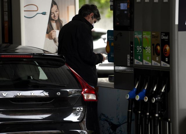 Archivo - Un home posa benzina al seu cotxe.