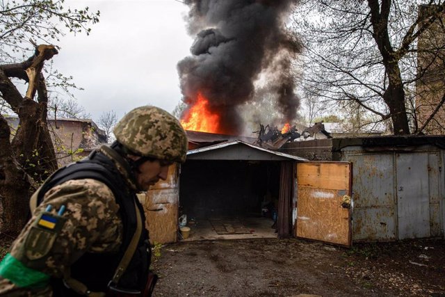 Un militar ucraniano pasa ante un garaje en llamas en Járkov, Ucrania