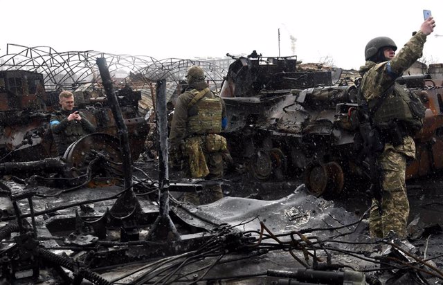 Soldados ucranianos se fotografían entre los escombros