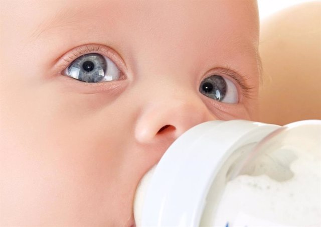 Archivo - Bebé bebiendo leche en un biberón.