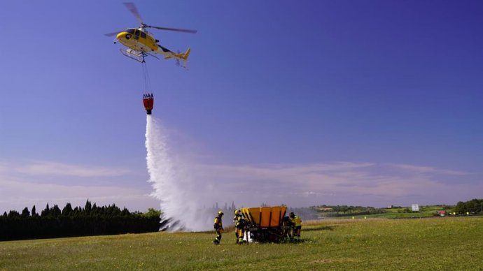Un helicóptero hace una demostración de descarga de agua durante la presentación de la campaña contra incendios forestales.