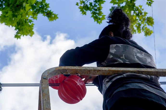 Operarios colocando los farolillos que iluminarán las calles del recinto ferial a tres días para la inauguración de la Feria de Abril de Sevilla 2022 después de dos años sin celebrarse por la pandemia a 27 de abril del 2022 en Sevilla (Andalucía, España)