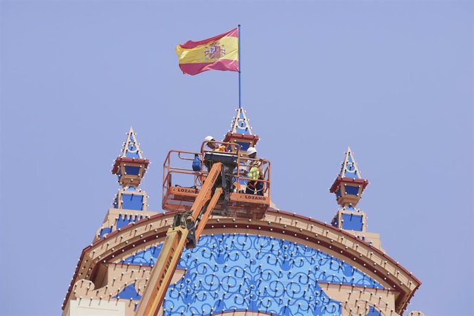 Dos operarios revisan las bombillas de la Portada durante la recogida de las llaves de la portada en el Real de la Feria, a 29 de abril de 2022 en Sevilla (Andalucía, España)