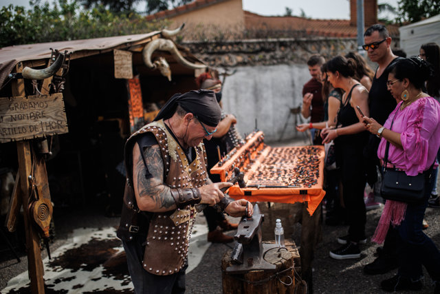 Un artesano de bisutería en un puesto en el mercadillo de la Feria Medieval de El Álamo