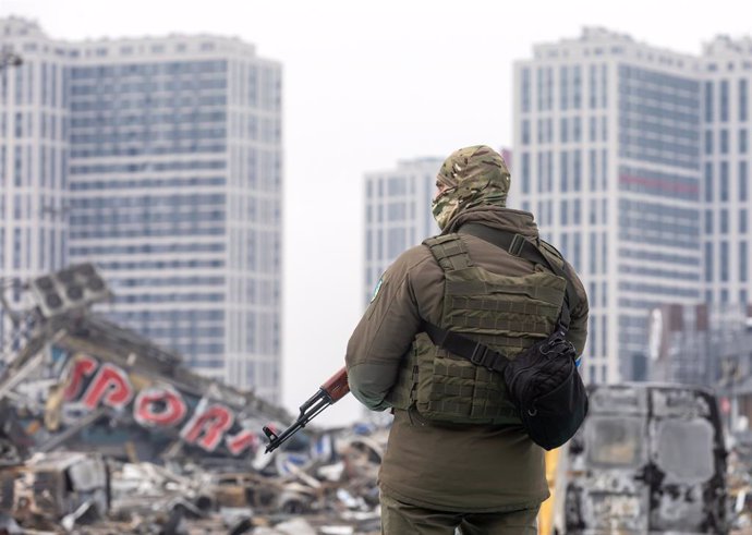 Un militar ucrans al costat d'un centre comercial destrut a Kíev