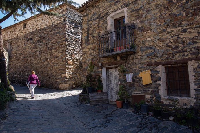 Una mujer en una de las calles de Patones de Arriba, a 6 de abril de 2022, en Patones de Arriba, Madrid (España). Patones de Arriba se ubica en el Valle del Jarama, a 60 kilómetros de Madrid y representa uno de los mejores ejemplos de arquitectura negr