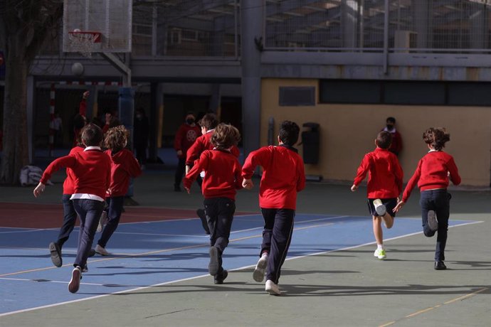 Archivo - Un grupo de niños corriendo por el patio de un colegio en Madrid