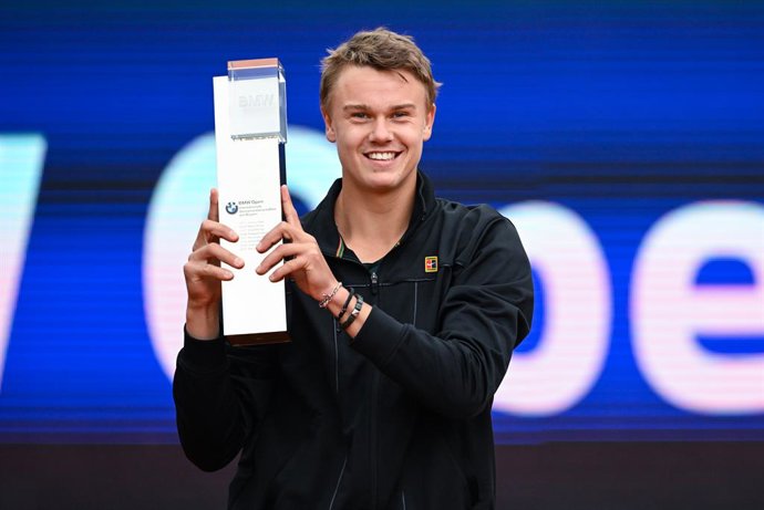 01 May 2022, Bavaria, Munich: Danish tennis player Holger Rune celebrates with thr trophy after defeating Netherlands' Botic van de Zandschulp in their men's singles final match at the ATP tennis BMW Open (Bavarian International Tennis Championships). P