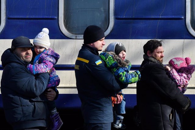 Archivo - 13 de marzo de 2022, Kramatorsk, Ucrania: Se ve a unos hombres llevando a los niños de la comunidad infantil para subir al tren de evacuación en la estación de tren de Kramatorsk.