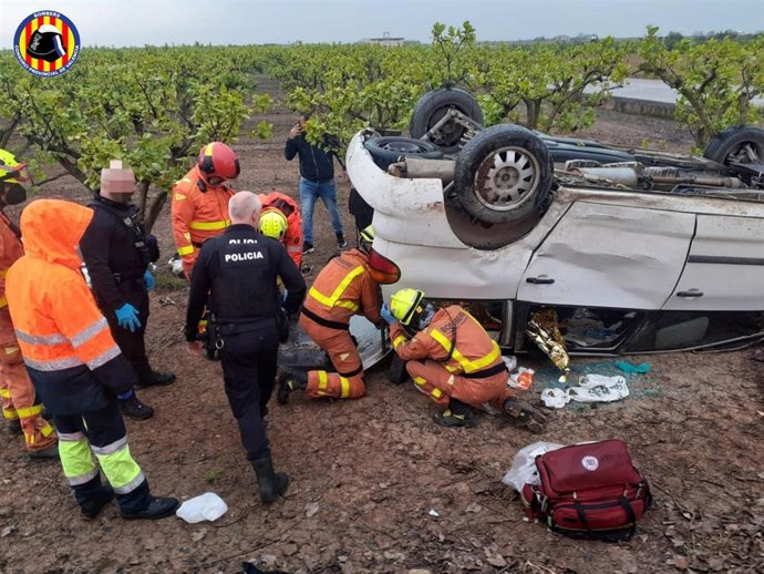Bomberos rescatan a dos personas atrapadas al volcar un coche tras colisionar con otro en Alginet