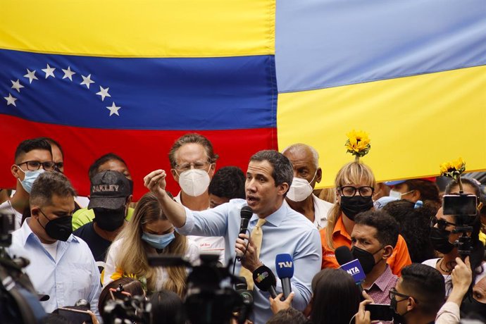 Archivo - 03 March 2022, Venezuela, Caracas: Juan Guaido (C), opposition leader in Venezuela, speaks during a rally for peace in Ukraine and against the Venezuelan government. Venezuelan President Maduro had condemned sanctions against Russia over its i