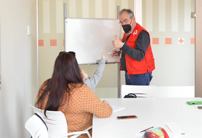 Archivo - Un voluntario de Cruz Roja en una clase de español a refugiados ucranianos en Córdoba
