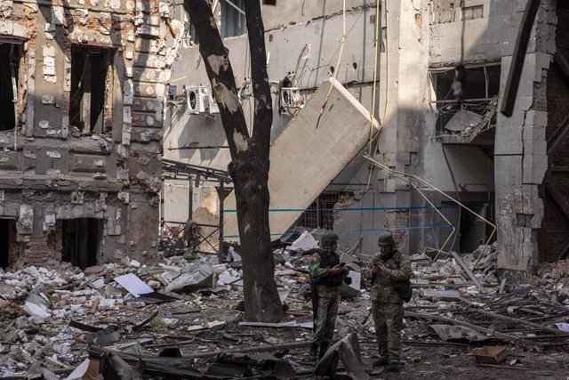 Dos soldados ucranianos en medio de los escombros en la ciudad de Járkov.