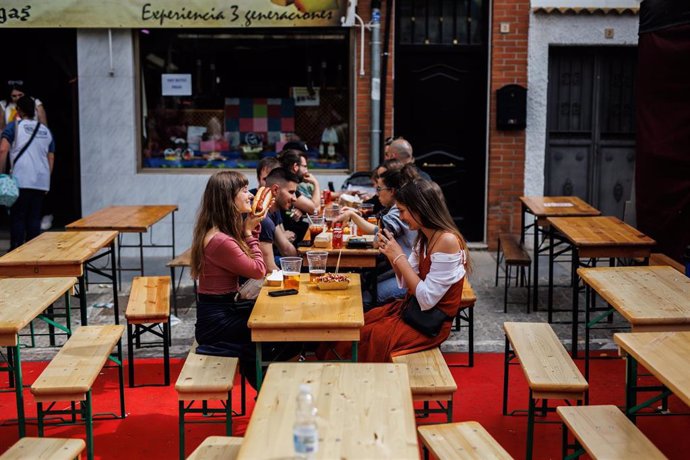 Varios jóvenes beben cerveza y comen algo, en la terraza de un bar, durante la Feria Medieval de El Álamo, a 30 de abril de 2022, en El Álamo, Madrid (España). Esta localidad celebra su XXV edición de la Feria Medieval, la única en la comunidad madrileñ