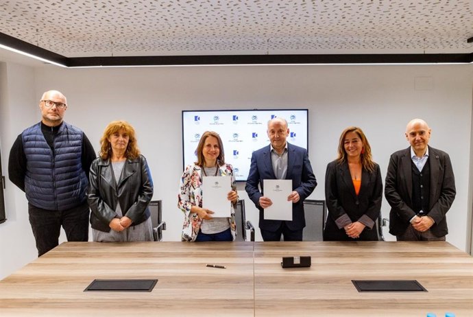 Rosa Gili i Josep Maria Mas, al centre, mostren l'acord signat.