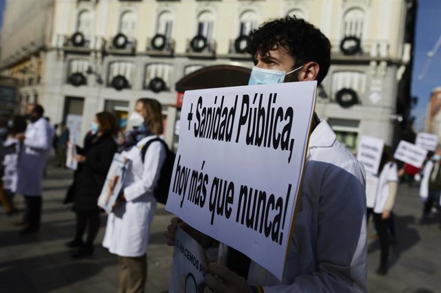 Archivo - Un trabajador sanitario sostiene una pancarta durante una concentración convocada por la Asociación de Médicos y Titulados Superiores de Madrid (AMYTS), en la Puerta del Sol