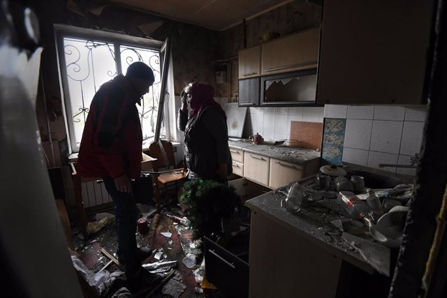 Dos personas comprueban los desperfectos de su apartamento en Bucha tras un bombardeo de las fuerzas rusas