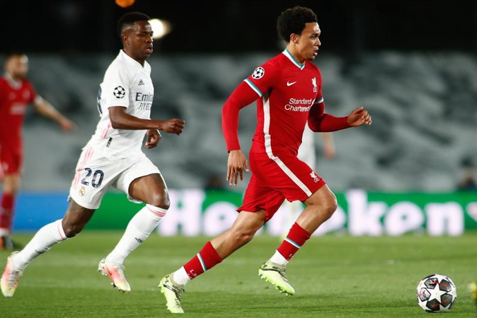 Archivo - El jugador del Liverpool Trent Alexander-Arnold conduce el balón delante del brasileño del Real Madrid Vinicius Junior en la ida de los cuartos de final de la Liga de Campeones 2020-2021.