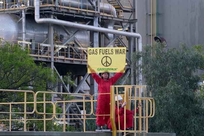 Una activista de Greenpeace en una central térmica de Málaga en una acción de protesta por el uso de gas ruso