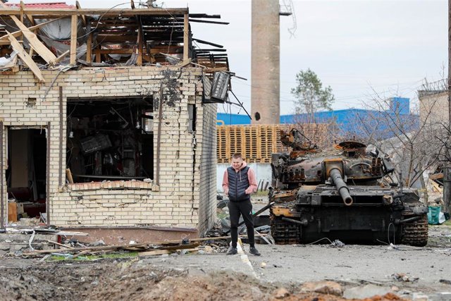 Un hombre cerca de los restos de un carro de combate de Rusia en la localidad de Bucha, situada en los alrededores de la capital de Ucrania, Kiev