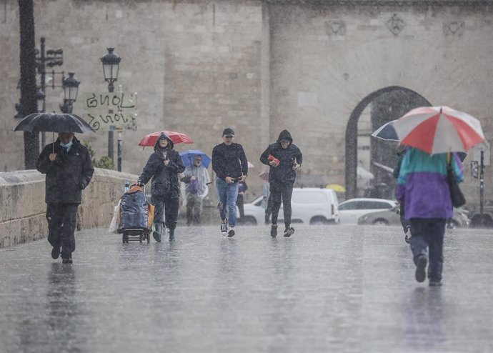 Varias personas con paraguas en una calle de Valencia, a 3 de mayo de 2022, en Valencia, Comunidad Valenciana (España). Valencia está registrando su primavera más húmeda en siglo y medio --con datos desde 1864-- y las lluvias de hoy han dejado ya 82,6 l