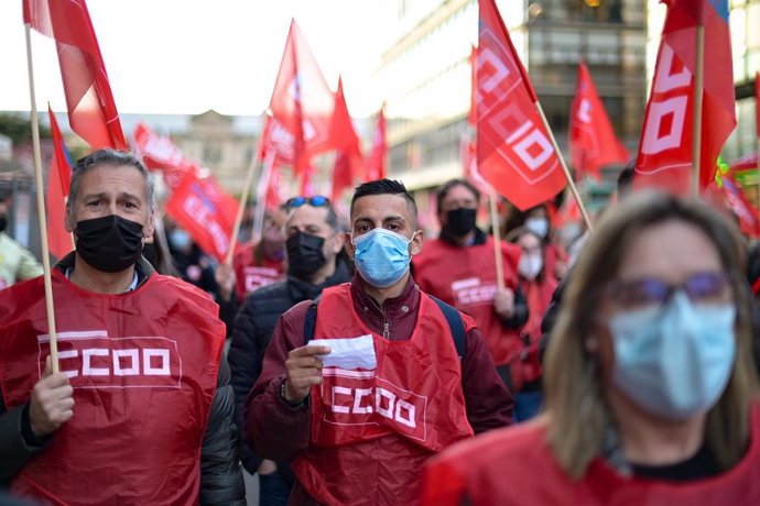 Archivo - Un grupo de personas sostiene banderines de CCOO en una imagen de archivo.