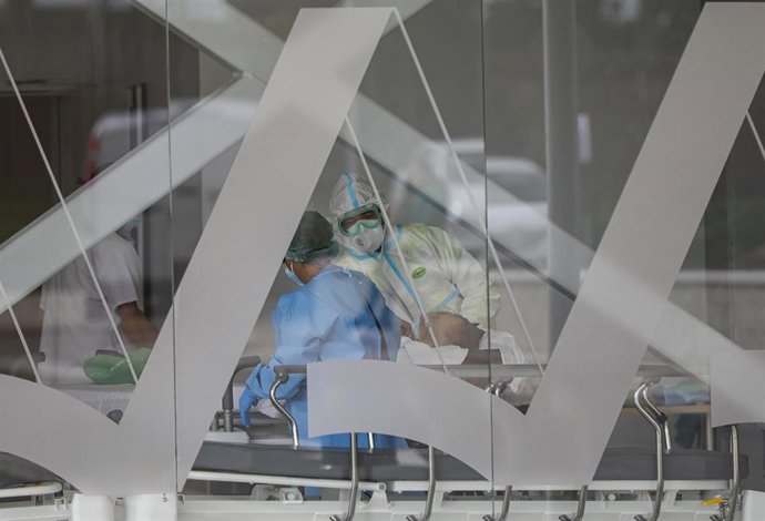 Archivo - Personal sanitario atiende a un paciente de coronavirus en el nuevo Hospital de Emergencia Covid-19, en foto de archivo.