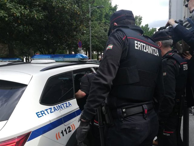 Agentes de la Ertzaintza introducen en el coche policial al detenido por su los homicidios de homosexuales en Bilbao, tras elñ registro en su domicilio de Irun
