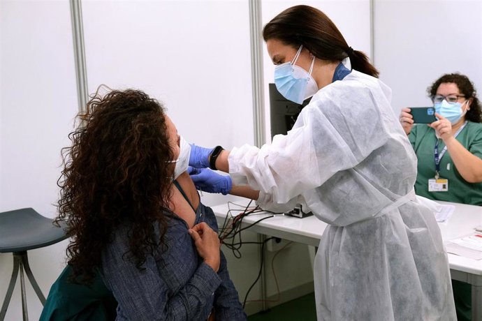 Archivo - Un empleada sanitaria suministra la vacuna contra la Covid-19. Archivo.
