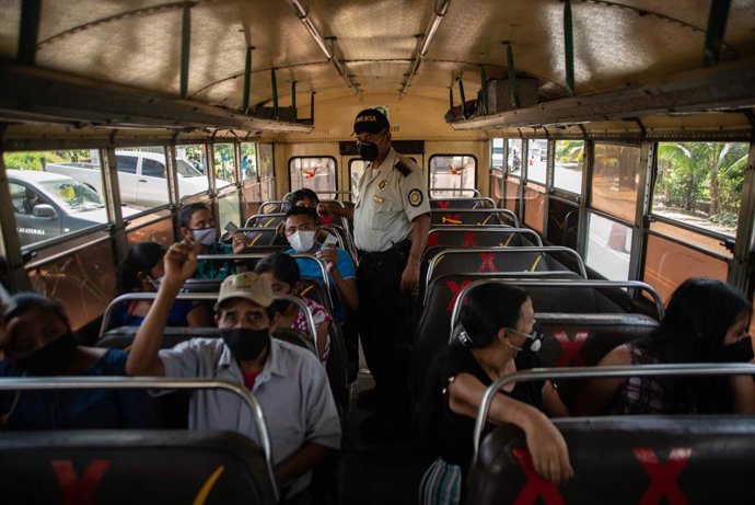 Archivo - 18 January 2021, Guatemala, Coatepeque: A member of the Guatemalan army checks the identification of all people inside a bus during an operation on the highway to detain illegal immigrants. several groups of thousands of migrants from Honduras
